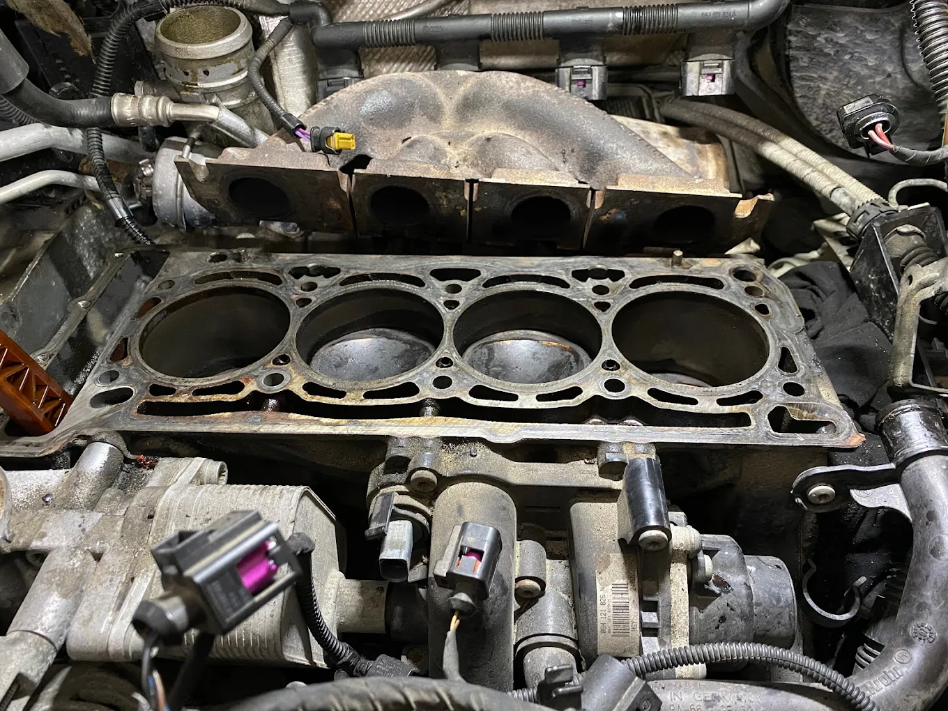 Blok silnika po demontażu głowicy podczas naprawy w warsztacie samochodowym.