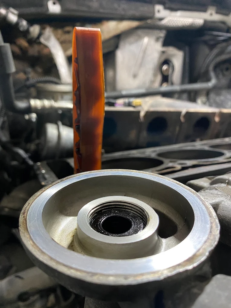 Koło pasowe i prowadnica łańcucha rozrządu w trakcie remontu jednostki napędowej.